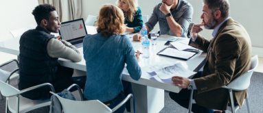 Businessman giving demonstrating on laptop to colleagues